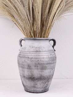 a vase with some dry grass in it