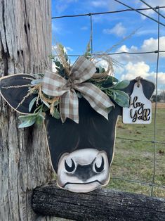 a cow head hanging on the side of a fence with a tag attached to it