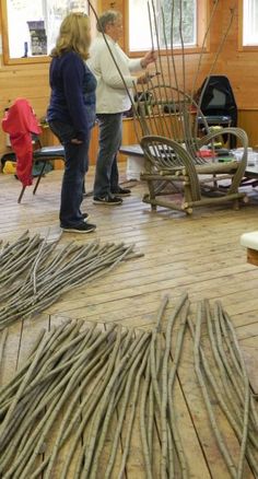 two women standing in a room with lots of sticks on the floor