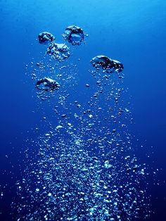 bubbles are floating in the blue water