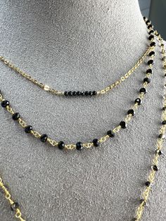 This is simple, beautiful necklace is comprised of 3mm Faceted Black Spinel hand-wrapped into a rosary style chain. Finished off with dangle of gold beads. Necklace length 16" with a 2" extender. Rosary chain is vermeil. All other components are gold filled. Dainty Gold Necklace With Black Beads, Gold Wire-wrapped Dangle Beaded Necklaces, Gold Wire Wrapped Dangle Beaded Necklaces, Black Beaded Lariat Necklace Gift, Gold Multi-strand Necklace With Black Beads, Black Layered Necklace With Adjustable Chain As Gift, Gold Beaded Chain Crystal Choker, Black Lariat Chain Necklace, Adjustable Double Strand Beaded Chain Necklace