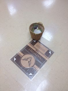 a small basket sitting on top of a floor next to a sign that says tim horton