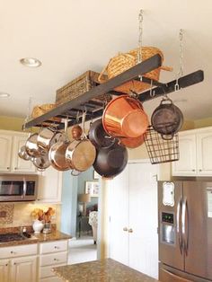 pots and pans hanging from the ceiling in a kitchen