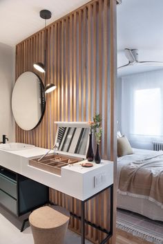 a bathroom with a sink, mirror and stool in front of a bed that is made out of wood slats