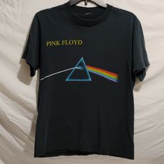 Rare! Vintage 90's Pink Floyd Dark Side Of The Moon Still First In Space Tee Shirt!! Colors Have Slightly Faded As Shown But Otherwise It's Great Condition! Size Tag Was Removed For Comfort! Unisex! Men's Or Women's! See Measurements Below: Measurements Laying Flat: Pit To Pit: 19 1/2". Length: 25 1/2". Smoke And Pet Free Home! Reasonable Offers Always Welcome! Unisex Pink Floyd Vintage, Space Tee, Pink Floyd Dark Side, Dark Side Of The Moon, In Space, Pink Floyd, Dark Side, Size Tag, Red Yellow