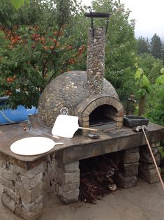 an outdoor stone oven with two pizza pans on it