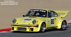 a yellow race car driving down a track with the number 80 on it's side