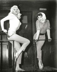 an old photo of two women posing on stools