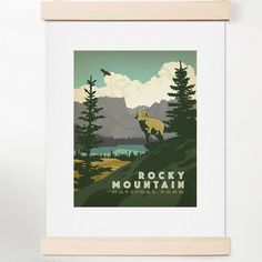 a framed print of rocky mountain with a bear and bird on it's back