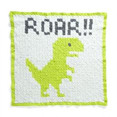 a green and white quilt with the word roar on it's side, in front of an image of a dinosaur