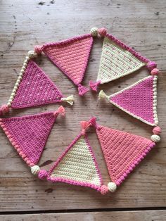 crocheted triangulars with tassels arranged on top of each other in pink and white