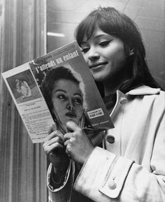 a woman reading a magazine while holding up her hair