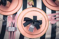 pink and black place setting with striped table cloth