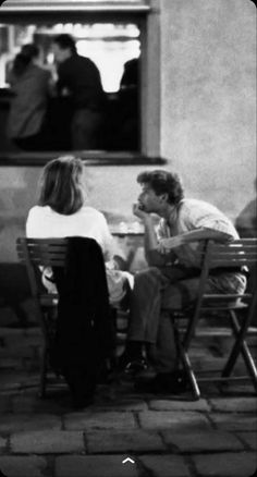 black and white photograph of people sitting at tables