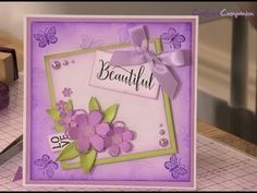 a close up of a greeting card with flowers and butterflies on the front, in purple