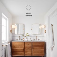 a bathroom with two sinks and three mirrors