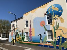 a mural on the side of a building with birds and flowers painted all over it