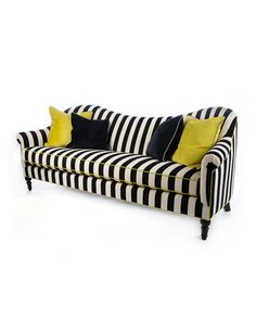 a black and white striped couch with yellow pillows on the arm rests against a white background