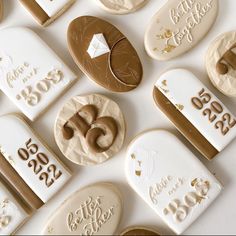 cookies decorated with gold and white icing are arranged on a table top for a 50th celebration