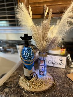 a bottle with some feathers in it sitting on a counter