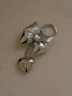 a metal key chain with a bow on it