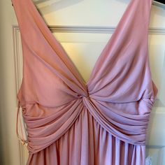 a pink dress hanging up on a hanger