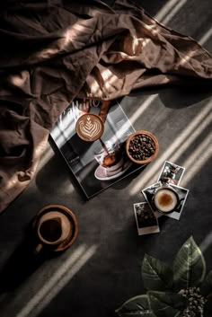 an overhead view of coffee and pastries on a table next to a window with the sun shining through