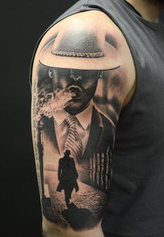 a man's arm with a black and white photo of a man in a hat