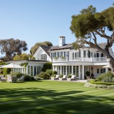 a large white house sitting on top of a lush green field