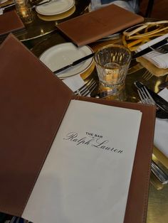 the table is set with an empty menu and silverware, glasses, and napkins