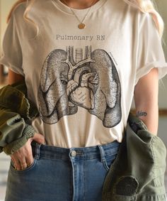 Treat the pulmonary registered nurse in your life with this Bella + Canvas unisex jersey short sleeve t-shirt! Whether you're searching for a nurse gift, new nurse graduation gift, or a gift for a nurse in the making, this vintage RN tee is professionally screen-printed on soft cotton for optimal quality and ultimate comfort no matter the occasion.   These t-shirts have-ribbed knit collars to bolster shaping. The shoulders have taping for better fit over time. Dual side seams hold the garment's shape for longer.  .: 100% Airlume combed and ringspun cotton (fiber content may vary for different colors) .: Light fabric (4.2 oz/yd² (142 g/m .: Retail fit .: Tear away label .: Runs true to size Care Recommendations: Non-chlorine: bleach as needed; Tumble dry: low heat; Iron, steam or dry: mediu Respiratory Therapy Shirts, Respiratory Therapist Aesthetic, Respiratory Therapist Shirts, Respiratory Therapy Humor, Nurse Coworker Gifts, Nurse In The Making, Nurse Tshirts, Therapy Humor, Body Human