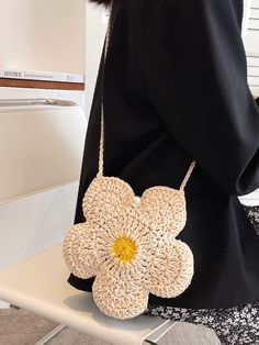 a woman is holding a crocheted flower purse