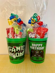 two plastic buckets filled with candy on top of a table