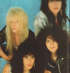 four women with long hair and piercings posing in front of a blue background,