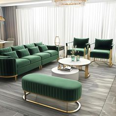 a living room filled with green couches next to a white coffee table and two chairs