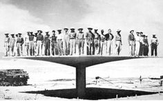 a group of men standing on top of a large structure in the middle of nowhere