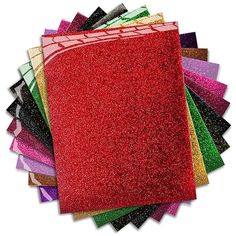 a bunch of different colored glitter paper on top of each other