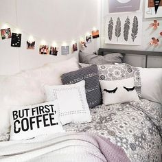 a bed with lots of pillows and pictures on the wall