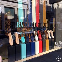 colorful shoes are displayed in the window of a store