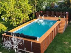 an above ground swimming pool in a backyard with wooden decking and fence around it