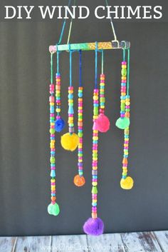 a colorful wind chime hanging on a wooden table with the words diy wind chimes