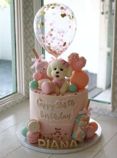 a birthday cake with a teddy bear and balloons