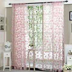 a living room with white furniture and pink curtains