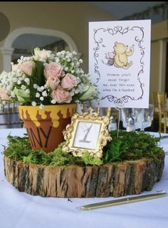 a potted plant sitting on top of a table next to a sign and flowers