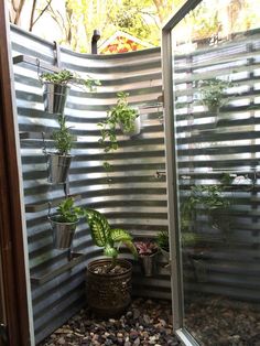 an outdoor shower with plants and rocks in it