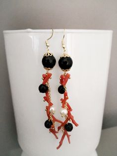 Baroque style earrings made of: - Faceted Onyx stones (10 mm), black color; - Faceted Onyx stones (8 mm), black color; - Natural Coral branches, red color; - Brass chain; - Gold plated Sterling Silver 925 hooks. Lenght : 10,5 cm / 4,13 inches These earrings are made with the utmost care and the utmost commitment to the technique, after a careful and meticulous research of the materials. The end result is a unique craftsmanship product and certainly different from its possible replication, given Elegant Red Coral Earrings, Elegant Red Earrings With Black Beads, Elegant Red Coral Jewelry With Matching Earrings, Elegant Red Coral Dangle Earrings, Elegant Red Coral Jewelry With Natural Stones, Black Earrings With Natural Stones For Gift, Black Natural Stone Dangle Earrings, Black Earrings With Natural Stones, Black Natural Stones Earrings For Gift