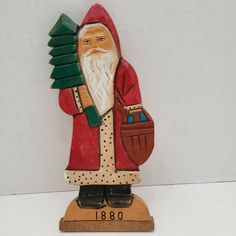 a statue of santa holding a christmas tree