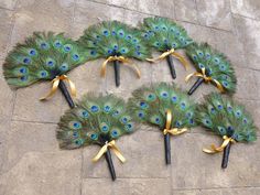 peacock feathers are arranged in the shape of a circle with black handles and gold ribbons