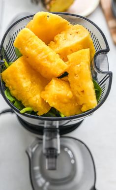 pineapple chunks in a juicer on a counter