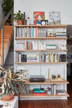 a bookshelf filled with lots of books next to a stair case